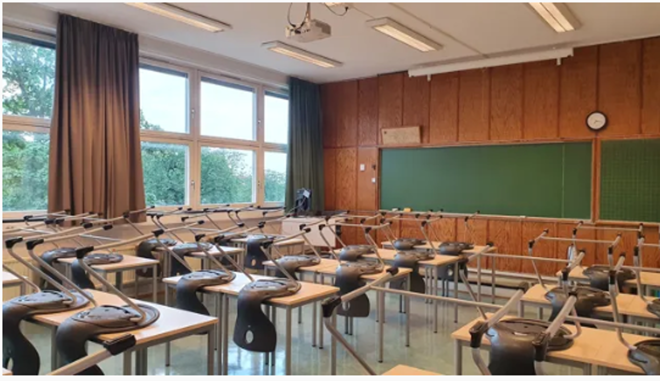 et klasserom med pulter og stoler