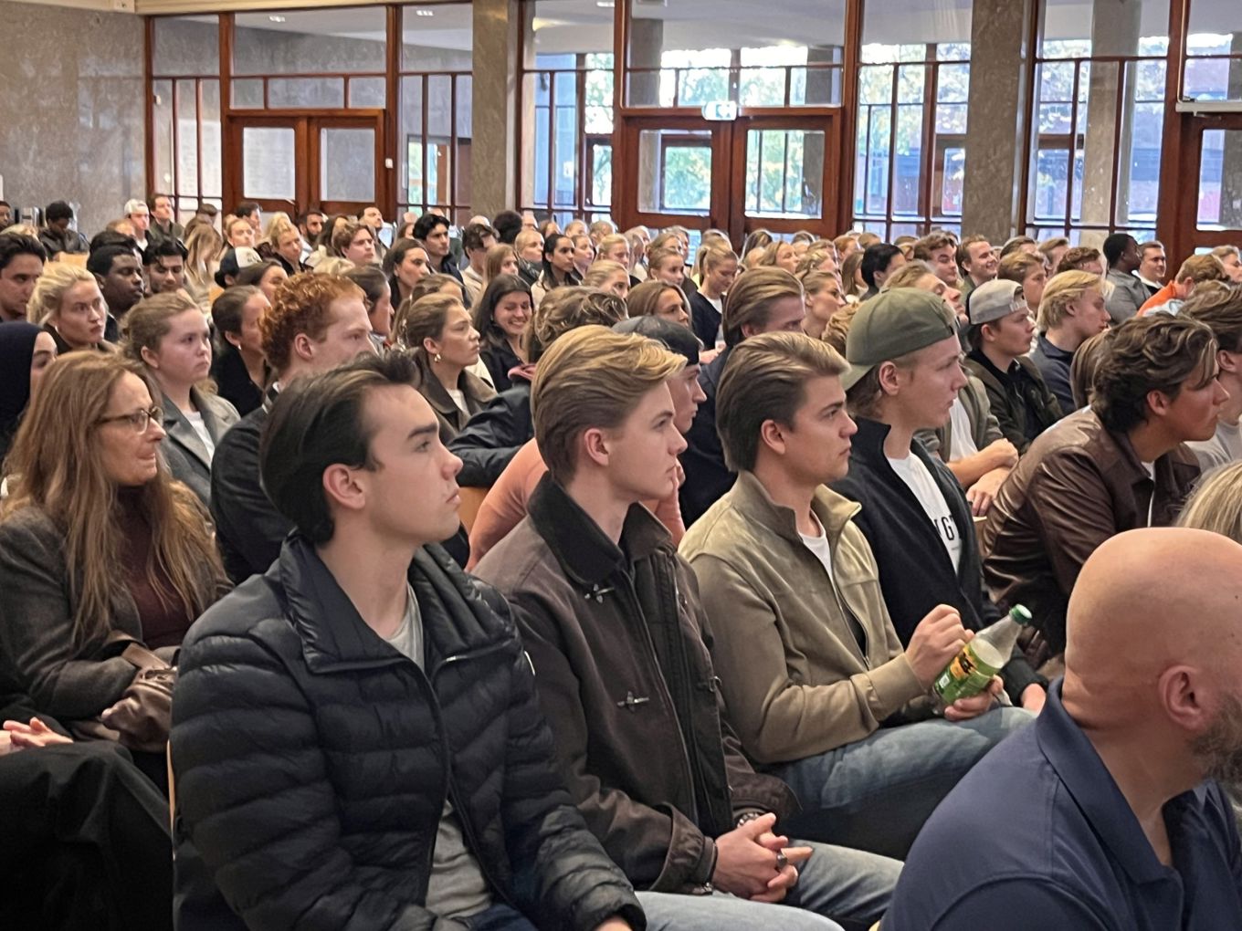 en stor gruppe mennesker som sitter i et rom en stor gruppe mennesker som sitter i et rom